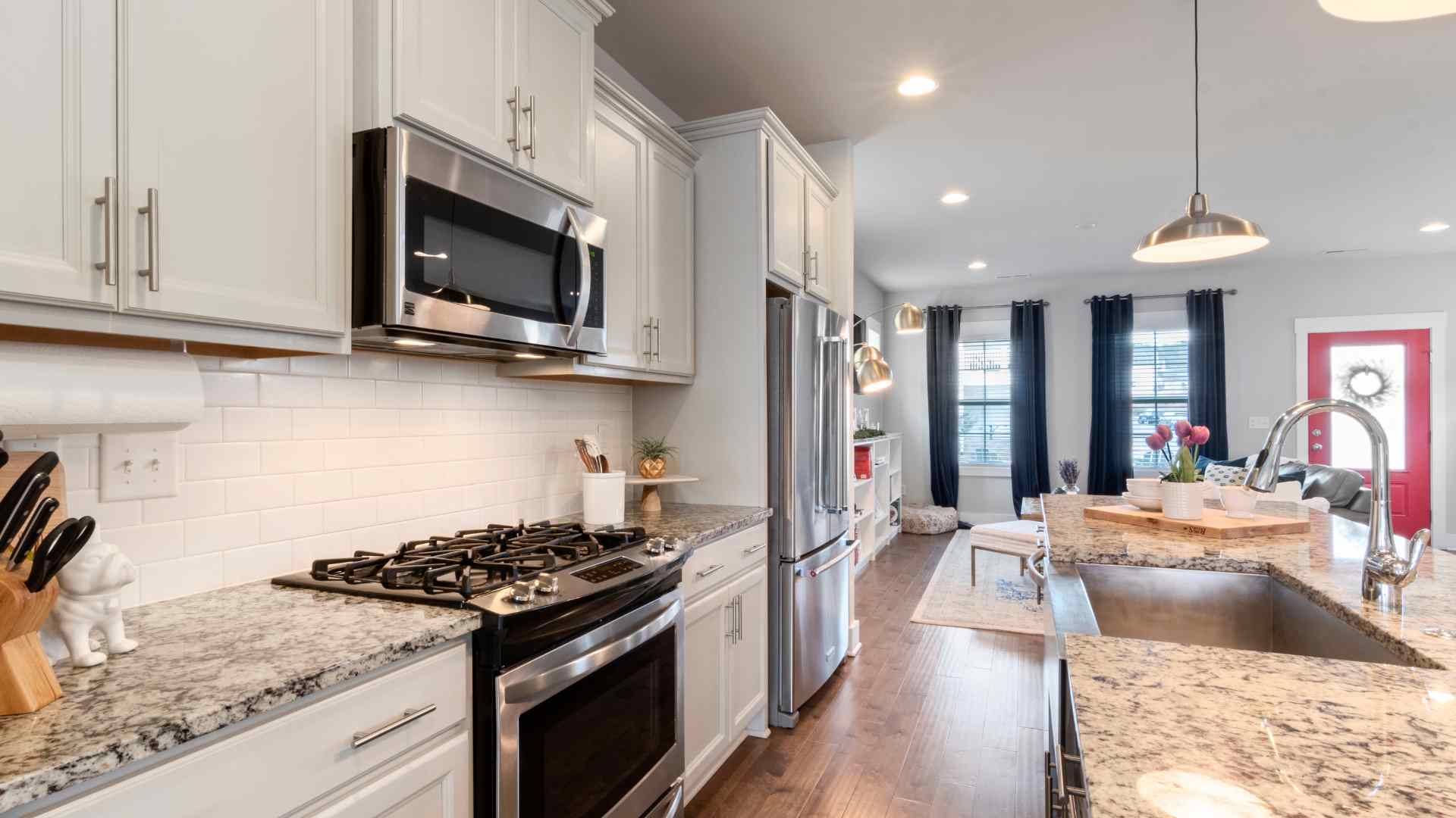 A kitchen with marble counter tops, a built-in oven, sink, and a separate kitchen island with its own sink